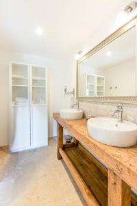 a bathroom with two sinks and a large mirror at La Bastide du Père Mathieu Jacuzzi couvert et Piscine in Suze-la-Rousse