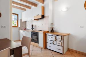 a small kitchen with white cabinets and a table at Apartment Goldener Schnee Tesero in Tesero