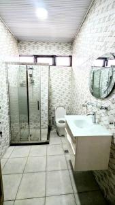 a bathroom with a shower and a sink and a toilet at SILVER RESIDENCE KIGALi in Kigali