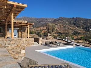 a villa with a swimming pool and a house at Ostria village in Mylopotas