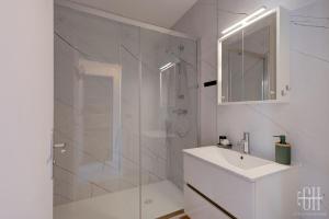 Un baño blanco con lavabo y ducha. en Terra - À 5 min du centre de Tours, en Tours 18 fotos más