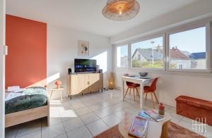 Un dormitorio con una cama, una mesa y un televisor. en Terra - À 5 min du centre de Tours, en Tours