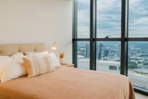 a bedroom with a large bed with a large window at Gleaming Riverfront - Stay on Casino, Free Carpark in Brisbane