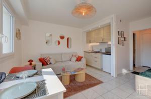 Una sala de estar con un sofá y una cocina. en Terra - À 5 min du centre de Tours, en Tours