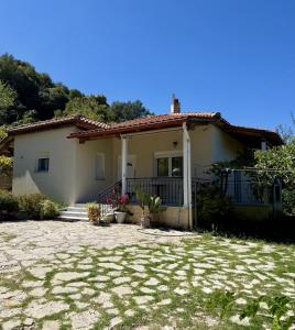 a small white house with a stone yard at Villa Lazaros in Aidoniá