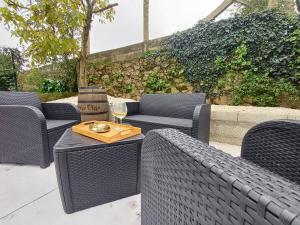a patio with chairs and a table with a glass of wine at M1 Preciosa casa reformada con gran patio exterior in Ourense
