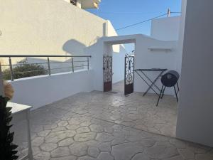 a balcony of a white building with a table on it at Traditional House 1925 in Gennadi