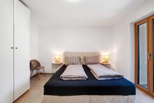 サン・レオナルド・イン・パッシーリアにあるSina Apartmentのランプ2つが備わる客室の大型ベッド1台分です。