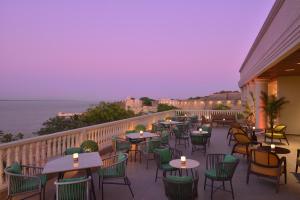 a restaurant with tables and chairs on a balcony at The Fort House, Diu- IHCL SeleQtions in Diu