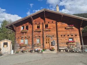 una baita di tronchi con fiori di fronte di Gemütliches Walliser Chalet Nahe Aletschgebiet a Blitzingen
