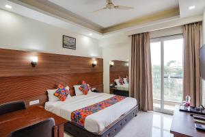 une chambre d'hôtel avec un grand lit et une fenêtre dans l'établissement FabHotel The Grace Inn Near Galleria Market & Golf Course Road, à Gurgaon
