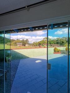 an open glass door with a view of a yard at Cantinho da Isa in Pomerode