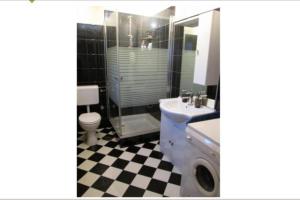 Un baño con lavabo e inodoro y suelo de tablero de ajedrez. en Apartment Glavica, en Supetar