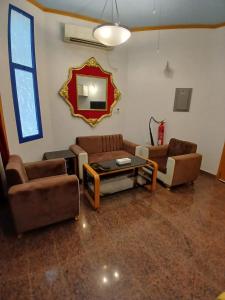 sala de estar con sofás, mesa y espejo en Qurum Heights Hotel, en Mascate