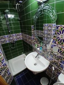 Un baño con lavabo, inodoro y ducha. en Qurum Heights Hotel, en Mascate
