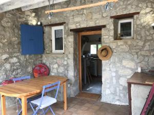a table and chairs in front of a stone wall at Les Eyssaux en Baronnies Provençales in Reilhanette