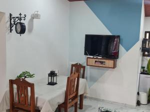 a dining room with a table and a tv on a wall at Sunset point 99 in Revadanda