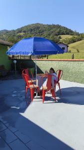 a woman sitting at a table under an umbrella at Cantinho da Isa in Pomerode