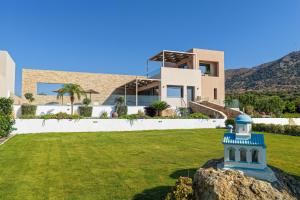 a house with a blue lighthouse in front of a yard at DS Luxury House in Kos Town