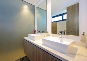 un bagno con due lavandini e un grande specchio di Silk Valley - 4B near Al Hamriyah | Private Pool a Al Ḩamrīyah
