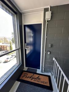Una puerta de entrada de un edificio con un cartel en ella en Parkside Apartment Near CBD & City Park with Parking, en Launceston