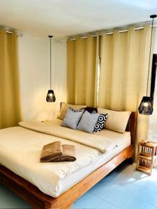 a bedroom with a large bed with pillows at THARA PHLU BUNGALOWS Koh Chang in Ko Chang