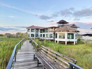 a boardwalk leading to a house on the beach at Nabua Thalenoi Resort in Ban Thale Noi
