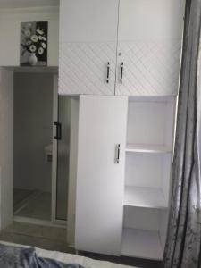 une armoire blanche avec un miroir dans une chambre dans l'établissement Acacia Sky, à Nakuru