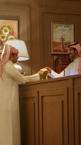 two men are standing at a bar in a room at The Classic Palace in Abha