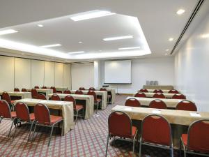 a conference room with tables and chairs and a whiteboard at Novotel Salvador Rio Vermelho in Salvador +95 photos
