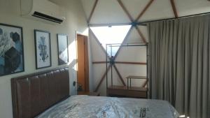 a bedroom with a large window and a bed at Domo com vista do Lago e Montanhas in Igaratá