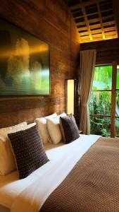 een slaapkamer met een groot wit bed met kussens bij Kaju Villa Canggu in Canggu