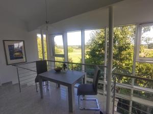 Un comedor con mesa y sillas y ventanas. en Alleeblick, en Fürth 5 fotos más