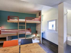 a room with two bunk beds and a table and chairs at HOTEL F1 Lyon Genay Massieux in Massieux