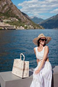 a woman in a straw hat with a shopping bag at Hotel Du Lac in Limone sul Garda