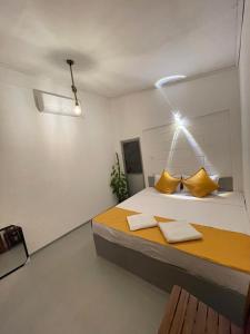 a bedroom with a large bed with yellow pillows at Elephant Side Safari Bungalow in Udawalawe