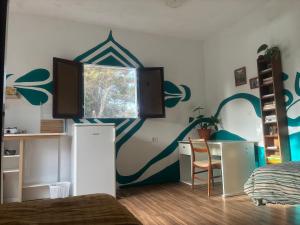 a bedroom with a wall with a painting on it at The Good Vibes Home in Hoya de Pineda