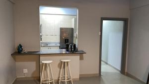 a kitchen with a counter with two bar stools at Akwabahouse in Durban