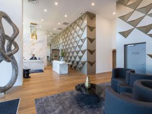 a lobby with a staircase and a reception desk at The Sebel Melbourne Malvern in Melbourne