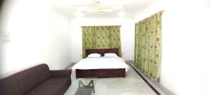 a small bedroom with a bed and a couch at Greenoriva Aero Srinagar in Srinagar