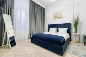 a bedroom with a blue bed and a mirror at Villa for rent with Garden - High Ceilings Bucharest Free Park in Bucharest