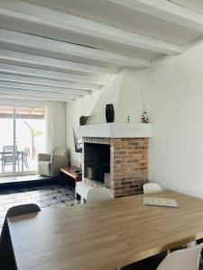 a living room with a table and a fireplace at Villa Los Remos in Corralejo