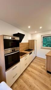 a kitchen with a stove and a sink at Ferienwohnung Anja in Münnerstadt