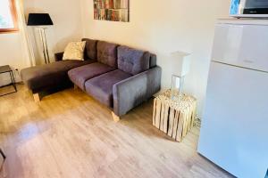 a living room with a brown couch and a refrigerator at Cozy Apartment next to the Slopes Sleeps 4 in Vars