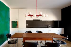a kitchen with a wooden table and black and white cabinets at Urban Design Loft - Basel - Free Parking in Basel
