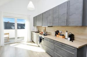 a kitchen with stainless steel cabinets and a large window at AT Weinmeister - außergewöhnlich & groß in Bielefeld