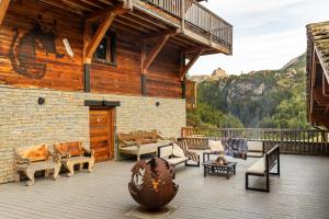 a large deck with furniture on a log building at Black Diamond - Chalet Tango in Les Brévières