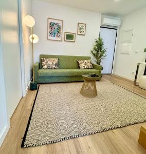 a living room with a green couch and a rug at Loving Porto Cozy Flat by MyMoradia in Porto +6 photos