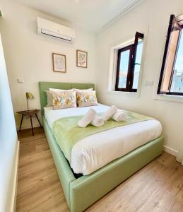 a bedroom with a large bed with towels on it at Loving Porto Cozy Flat by MyMoradia in Porto