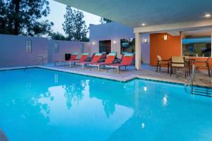 a swimming pool with chairs and a table at Studio City 2br w pool gym wd nr Olive Ave LAX-922 in Los Angeles